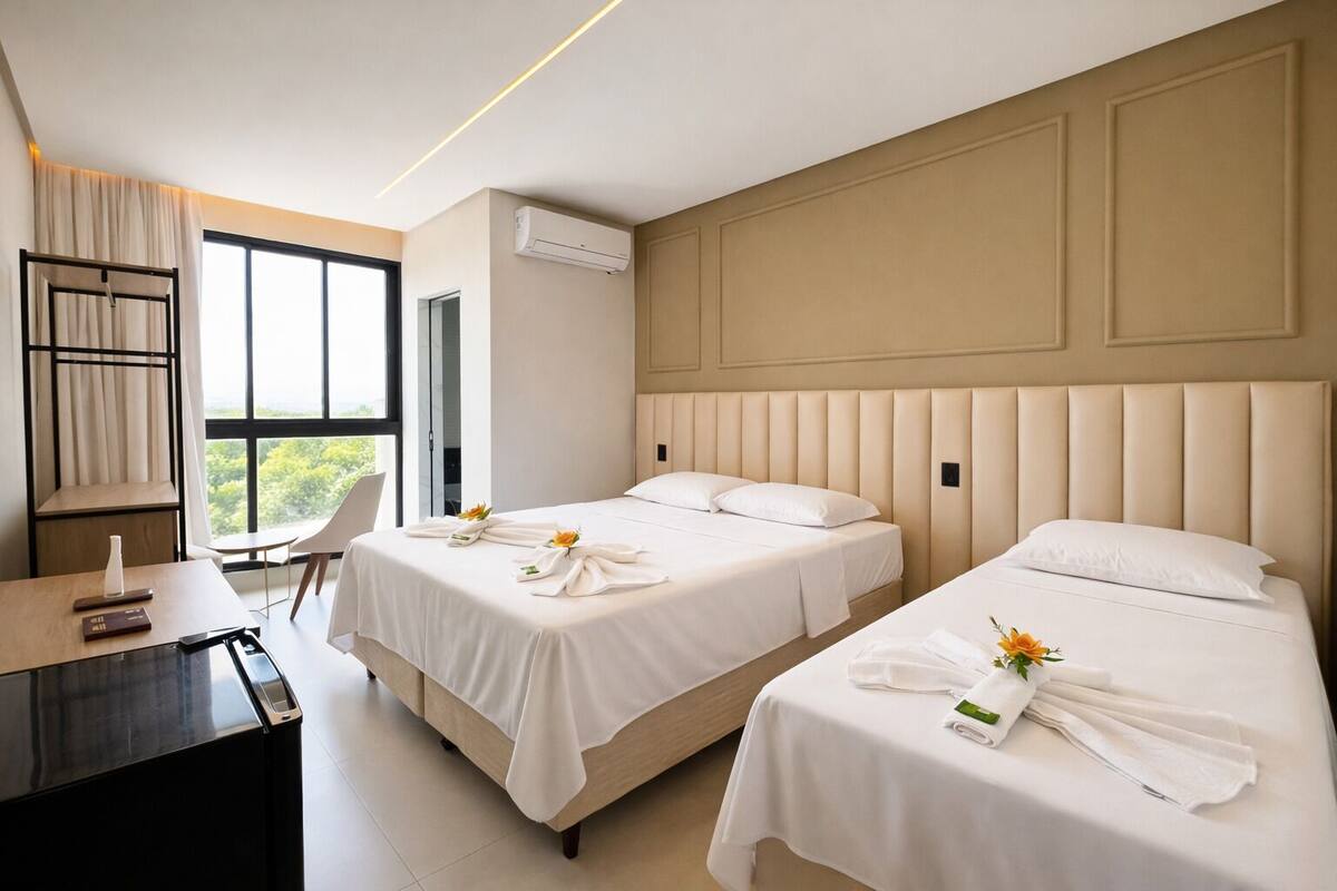 A hotel room with two beds, a desk, and a chair.
