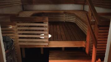 A sauna with wooden benches and a sloped ceiling.