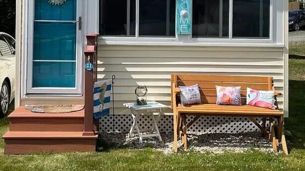 A small, single-story house with a front porch, a bench, and a mailbox. - Charming 1-bedroom cottage in York perfect for a relaxing getaway. (York)
