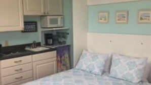 A bedroom with a bed, a nightstand, a dresser, and a microwave. - Charming 1-bedroom cottage in York perfect for a relaxing getaway. (York)