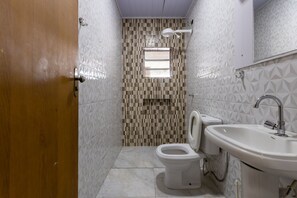 A bathroom with a toilet, sink, and a window. - Casa  piscina a 180m da Praia Boraceia (Bertioga)