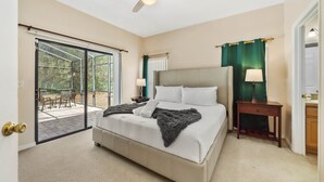 A bedroom with a large bed, a ceiling fan, a sliding glass door to a patio, and a nightstand with a lamp. - Epic Princess and Villains Hideaway-  Private Pool  Themed Rooms  Near Disney (Kissimmee)