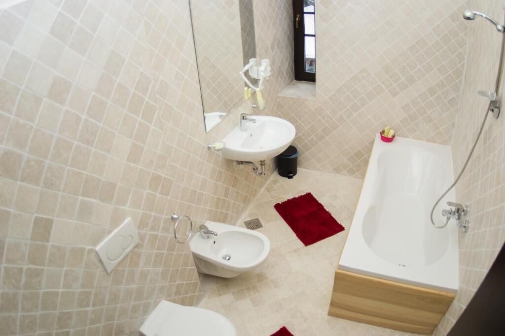 Une salle de bain équipée d’une baignoire, d’un bidet, d’un lavabo et de toilettes.