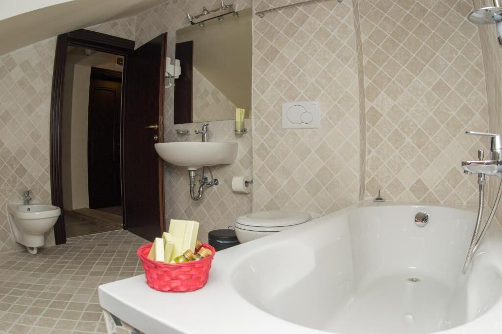 A bathroom with a bathtub, sink, bidet, and toilet.