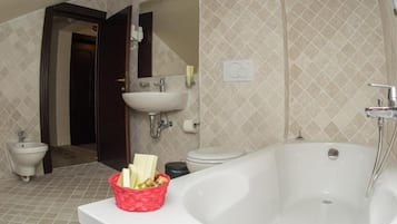 A bathroom with a bathtub, sink, bidet, and toilet.