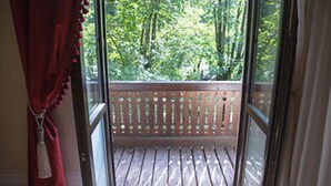 A wooden deck with a railing, a door, and a view of trees through the railing. - HOTEL REGAL 1880 - Boutique Hotel Sinaia (Sinaia)
