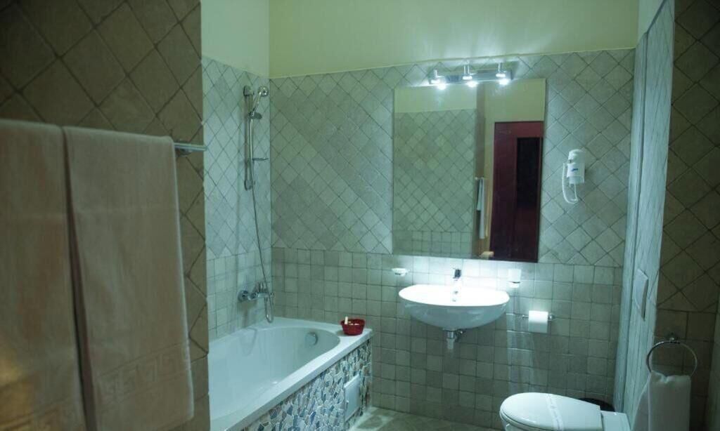 A bathroom with a bathtub, a sink, a toilet, and a shower.
