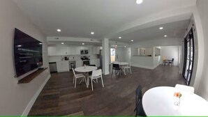 A spacious open-plan living area with a kitchen, dining area, and a small seating space. - The Urban Oasis (Cleveland)