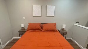 Een slaapkamer met een groot bed, twee nachtkastjes en een bedbank.