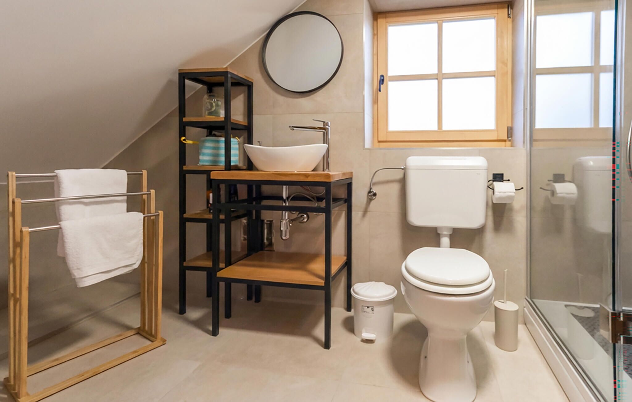 Een kleine badkamer met toilet, wastafel en een klein kastje.