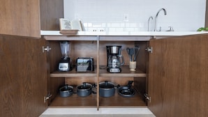 A compact kitchen with wooden cabinets, a white countertop, and a built-in sink.