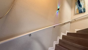 Un escalier doté d’une rampe et d’un luminaire fixé au mur.