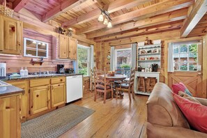 A wooden cabin interior with a kitchen, dining area, and a cozy living space. - Hot Tub, Sauna, Pool Table, Free Dollywood, Spa (Gatlinburg)