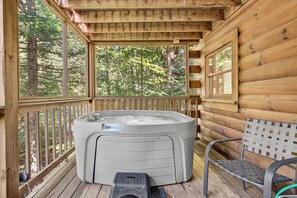 A wooden cabin with a hot tub, a bench, and a view of a forest. - Hot Tub, Sauna, Pool Table, Free Dollywood, Spa (Gatlinburg)