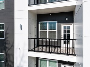 Een meerlaags gebouw met een balkon, een deur en ramen.