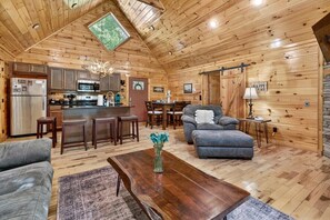 A cozy cabin interior with a kitchen, dining area, and living room. - Free Tickets,Sauna,Cold Plunge,Gatlinburg, 1 level (Gatlinburg)