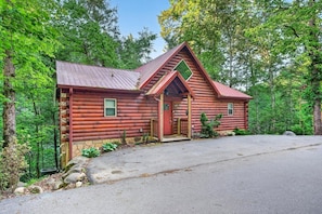 A log cabin with a stone foundation, a red door, and a small porch. - Free Tickets,Sauna,Cold Plunge,Gatlinburg, 1 level (Gatlinburg)