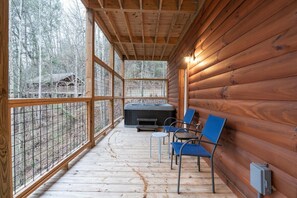 A wooden cabin with a deck, a hot tub, and two chairs. - Hot Tub & Dolly Tickets - Gatlinburg Cabin Retreat (Gatlinburg)