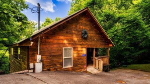 Une cabane en bois avec un porche, une cheminée et une porte portant le numéro « 4114 ».