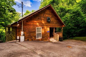 Une cabane en bois avec un porche, une cheminée et une porte portant le numéro « 4114 ».