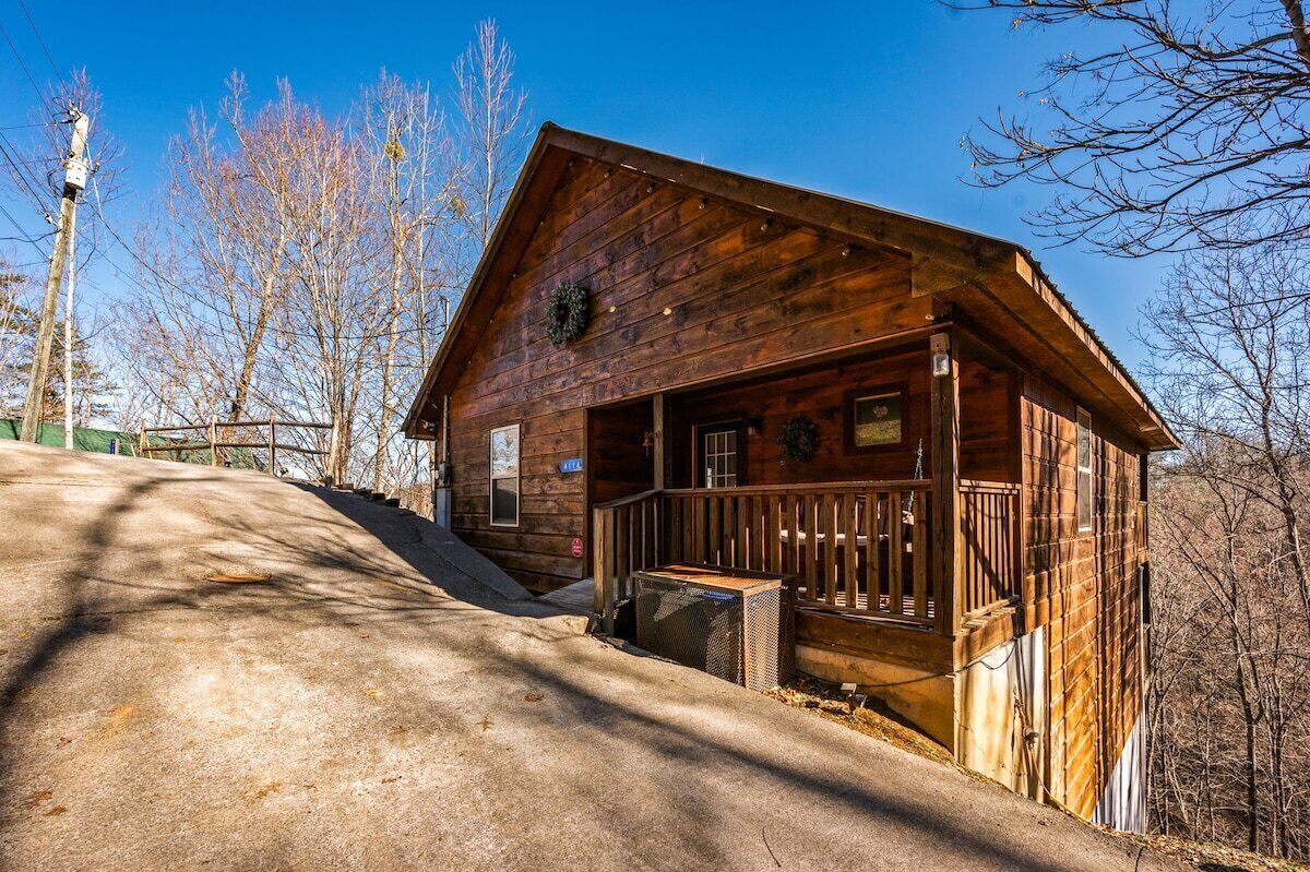 Een houten hut met een veranda, schoorsteen en brievenbus.