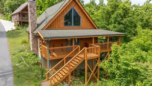 Une cabine dotée d’un balcon, d’un escalier et d’une grande fenêtre.