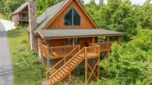 A cabin with a balcony, a staircase, and a large window. - Sauna,Cold Plunge,Hot Tub,Free Tickets,Resort Pool (Sevierville)