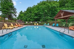 A swimming pool with lounge chairs and a covered seating area. - Sauna,Cold Plunge,Hot Tub,Free Tickets,Resort Pool (Sevierville)