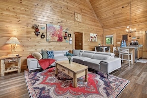 A wooden interior with a sofa, coffee table, and a patterned rug. - Sauna,Cold Plunge,Hot Tub,Free Tickets,Resort Pool (Sevierville)
