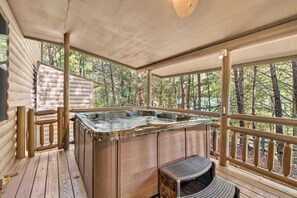 A wooden deck with a hot tub, wooden railings, and a view of a forest. - Free Dollywood, Hot Tub, Firepit, Pool Table, Spa (Gatlinburg)
