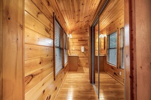 A wooden interior hallway with a wooden floor, a sink, and a window with blinds. - Free Dollywood, Hot Tub, Firepit, Pool Table, Spa (Gatlinburg)
