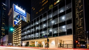 Et moderne hotel med en stor reklameplakat for Bud Light, en glasfacade og en veloplyst indgang.