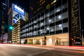 Ein modernes Hotel mit einer großen Werbetafel für Bud Light, einer Glasfassade und einem gut beleuchteten Eingang.