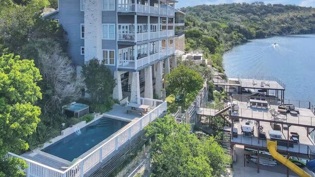 Ein mehrstöckiges Gebäude mit Balkonen, einem Pool und einer Anlegestelle, die sich über Wasser erstreckt.