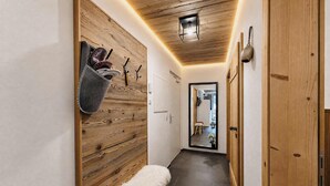 Un couloir avec un mur en bois, un banc et une porte.