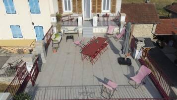 Een terras met buitenmeubilair, een tafel en een leuning.