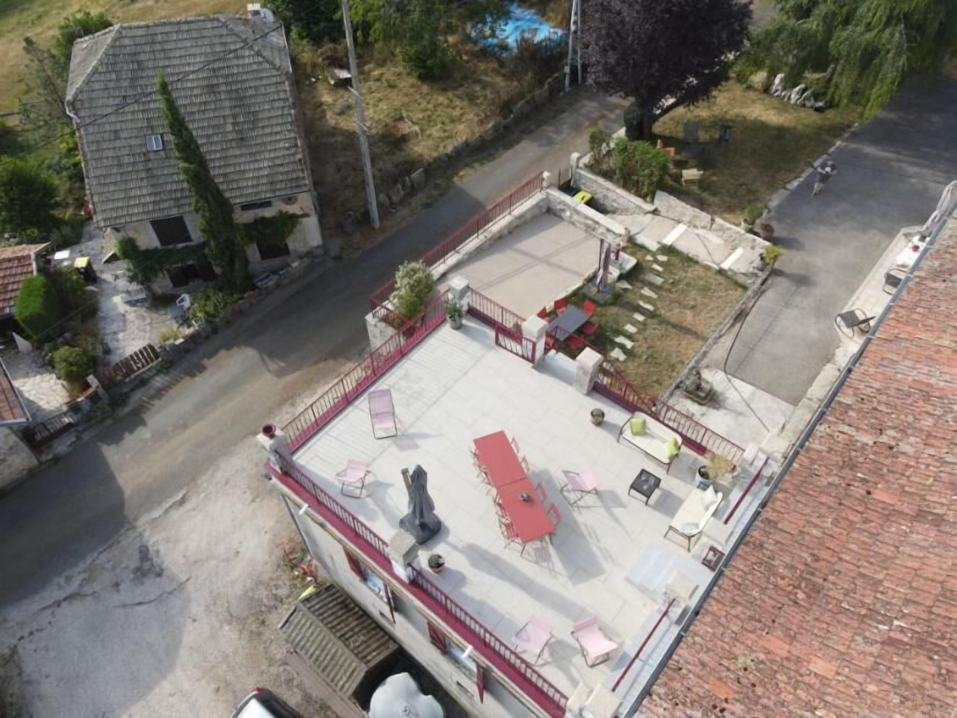 Een terras op het dak met buitenmeubilair, een klein zwembad en een omheind gebied.