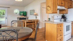 Una cocina compacta con armarios de madera, un refrigerador blanco y una estufa.