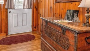 Un intérieur en bois avec un bureau, des livres et une lampe.