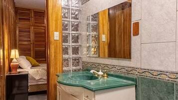 A bathroom with a glass sink, wooden cabinets, and a mirror.