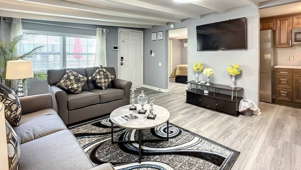 A modern living room with a grey sofa, a coffee table, and a TV mounted on the wall.