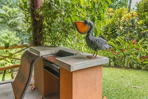 Une sculpture d’oiseau sur une structure en béton, avec une grille en dessous.