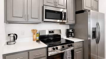 A modern kitchen with stainless steel appliances, including a microwave, oven, and refrigerator.