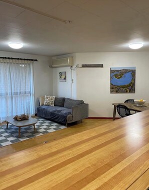 Un salon avec un canapé, une table à manger et un tableau accroché au mur.