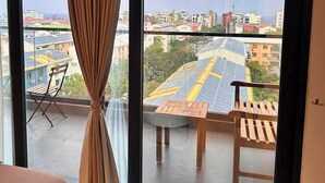 A balcony with a view of a cityscape, including buildings and solar panels. - Luxury 3-bedroom apartment in Hulhumale,Maldives (Malé)
