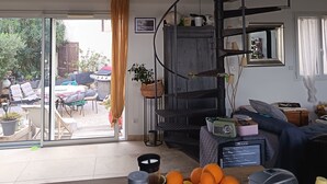 A spacious living area with a high ceiling, a mezzanine level, and a view of the outdoor patio. - Lotf au stes maries de la mer (Saintes-Maries-de-la-Mer)