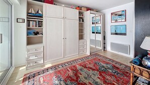 Une pièce avec une grande armoire, un tapis rouge à motifs et un miroir orné d’une image de vélo.