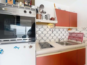 A kitchen with a refrigerator, oven, and sink. - QUIBERON - 2 rooms - 37m2 - Sea View (QUIBERON)