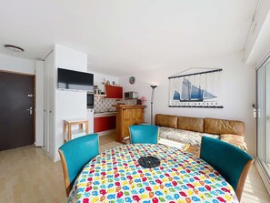 A compact living space with a kitchenette, a dining area with a colorful table, and a sofa with a patterned cover. - QUIBERON - 2 rooms - 37m2 - Sea View (QUIBERON)