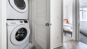 A laundry room with two white front-loading washing machines. - Cozy Stay Near San Diego With 2 Car Garage (Lemon Grove)